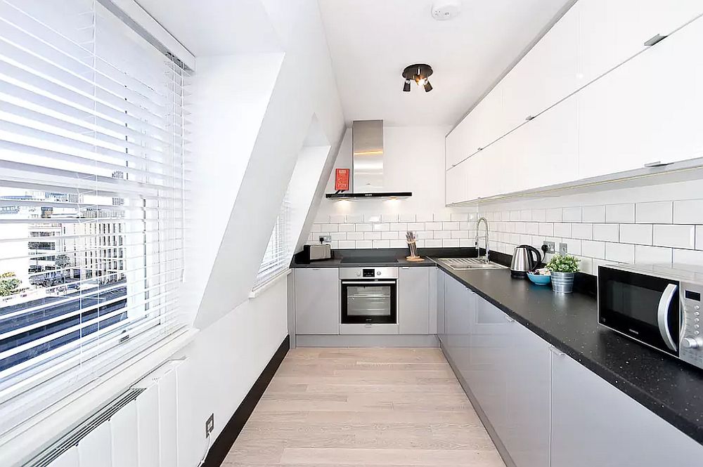 Space-savvy-L-shaped-kitchen-in-white-with-black-countertop