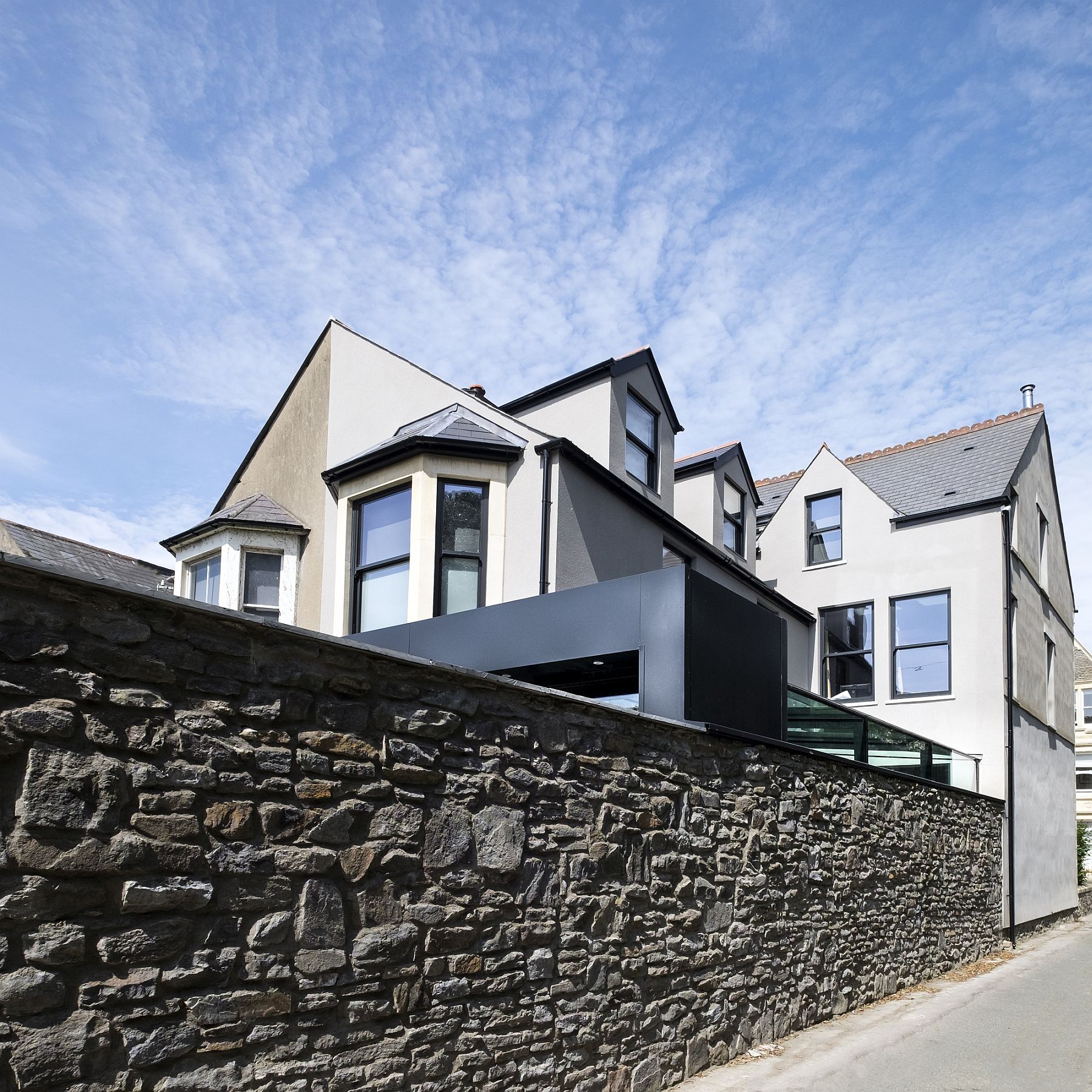 Striking aluminum extension of the Victorian House is partly visible from the street