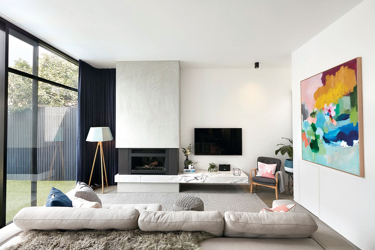 Art work brings color to the monochromatic living space with ample natural light