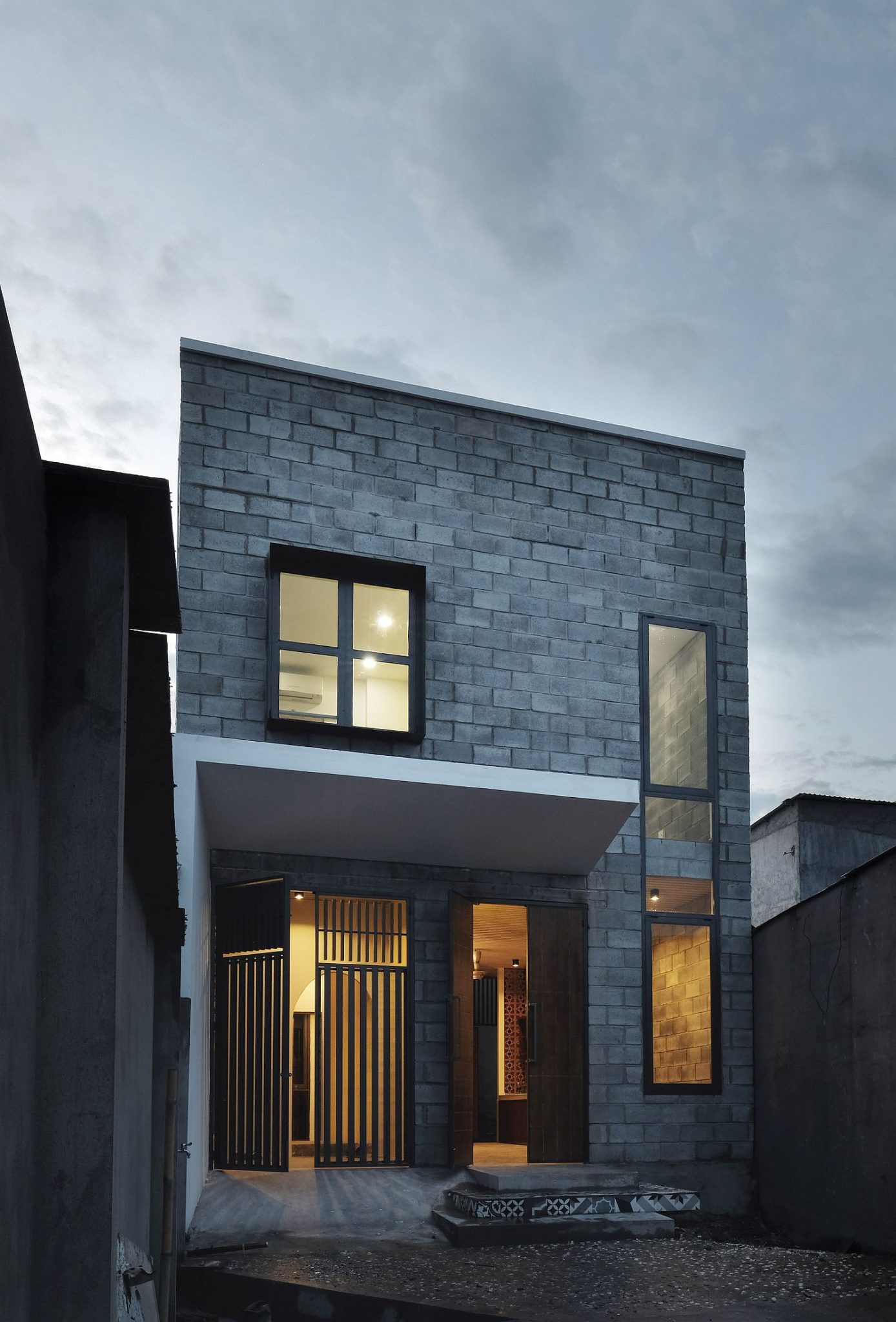 Concrete blocks and glass shape the exterior of the budget-friendly home in Vietnam