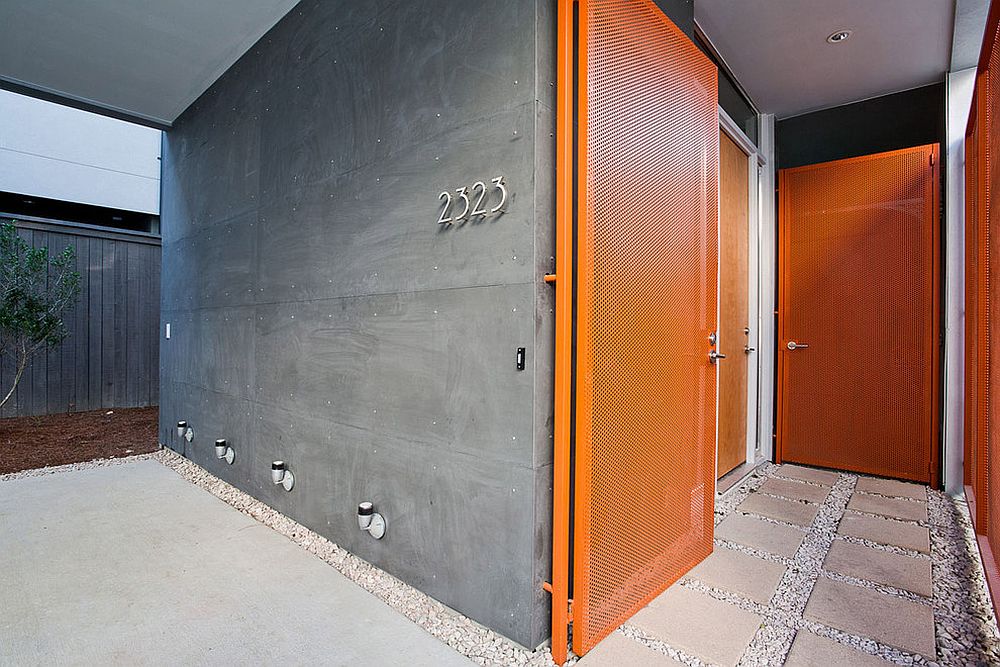 Contemporary entry with orange door and concrete walls is a showstopper!