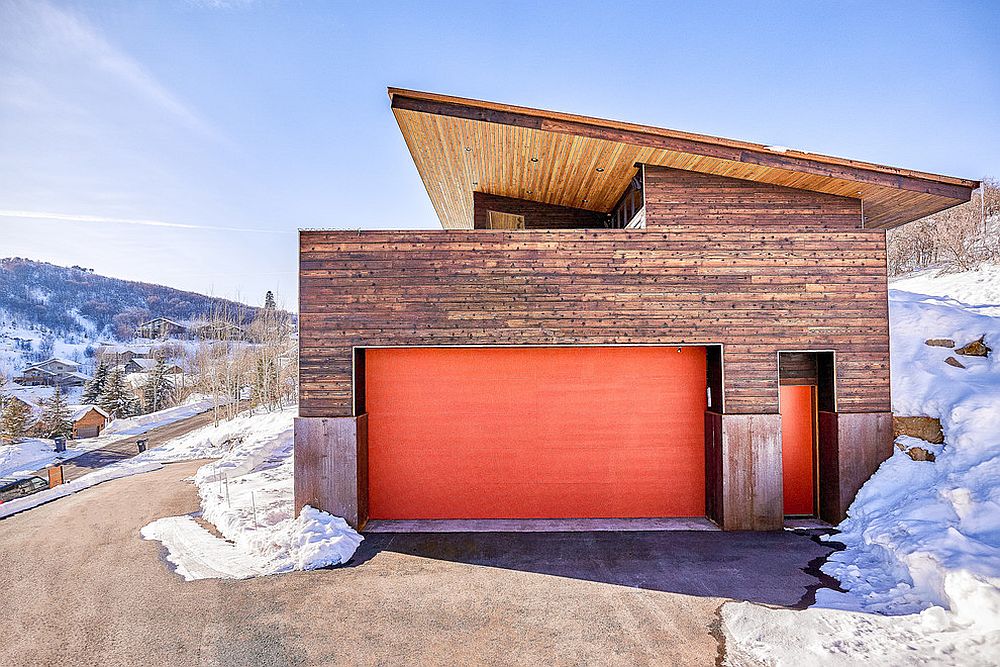 Contemporary garage in wood with bright orange doors