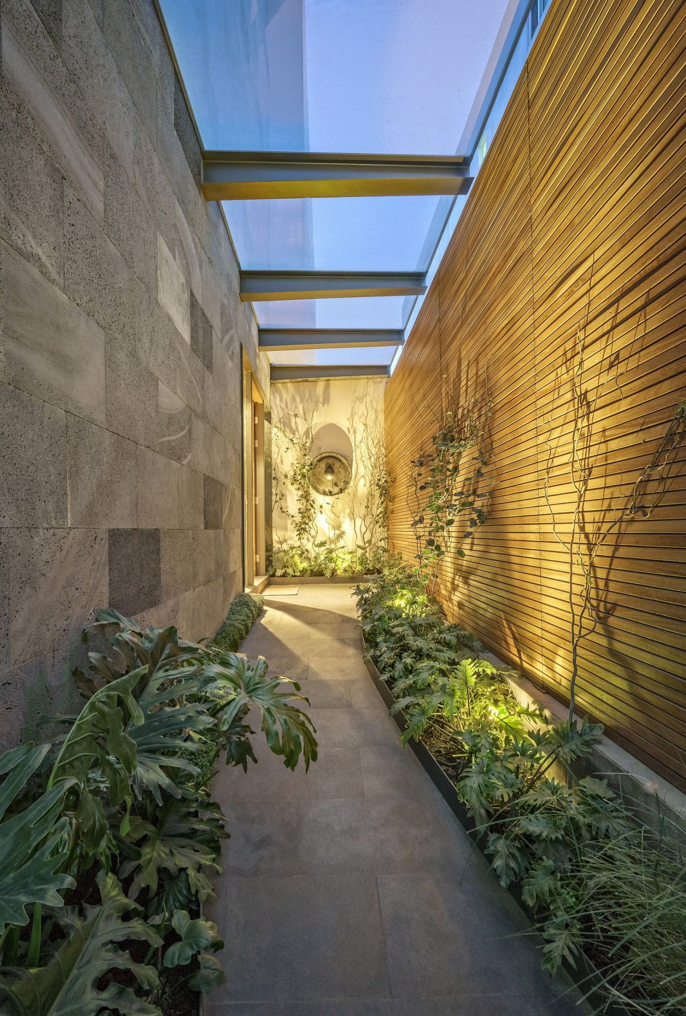 Covered and illuminated walkway connects the central courtyard with the garden