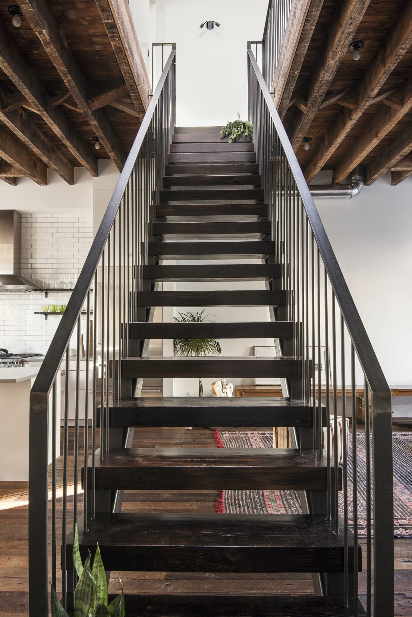 Custom wood and steel stairway leading to the private, bedroom level