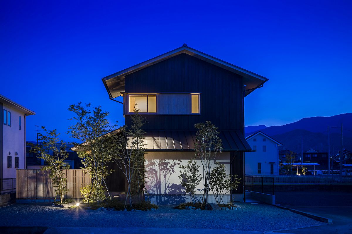 Dark exterior of modern Japanese home with traditional silhouette