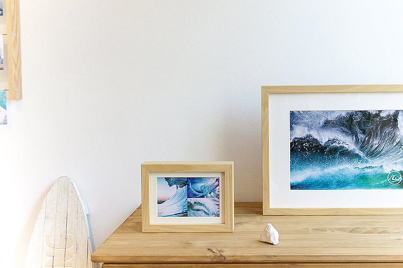 Framed images of sand and surf add to the beach style of the bedroom