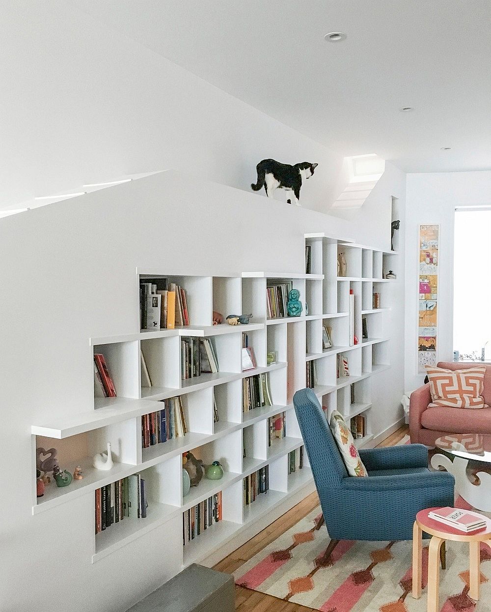 Full length bookshelf also serves as cat circulation