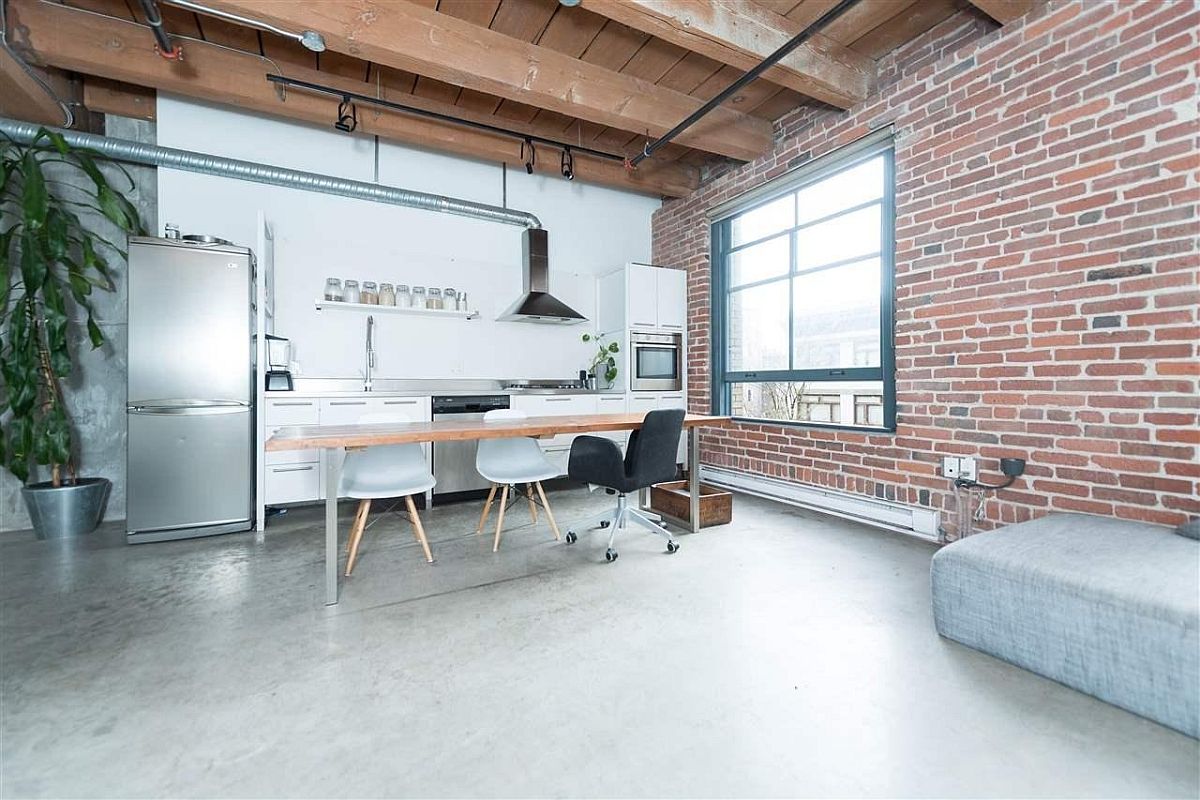 Open duct pipes, brick wall and concrete floor create a lovely kitchen for open plan living