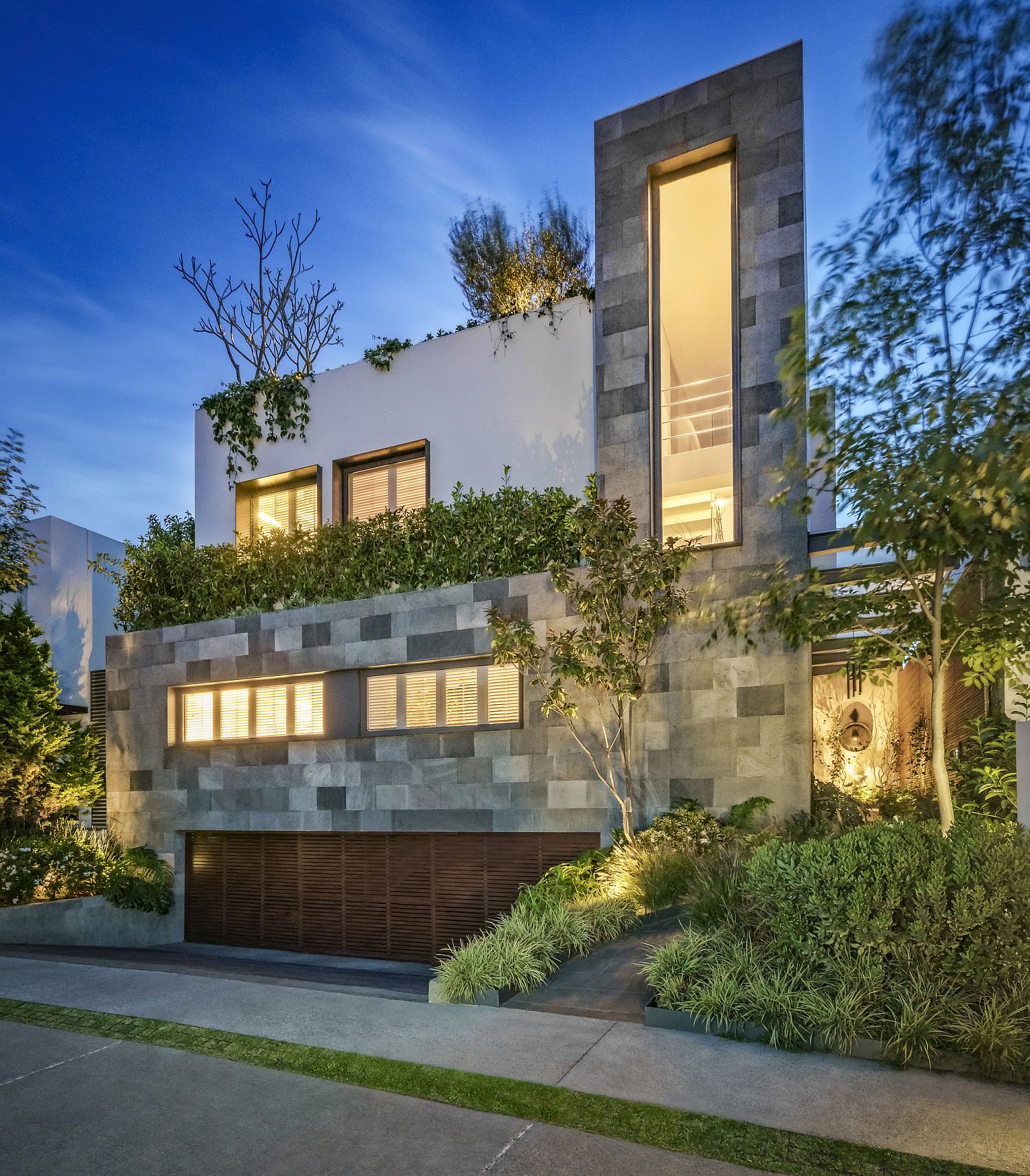 Private street facade of Mexican home draped in green