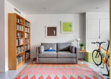 Sitting-and-media-room-with-comfortable-gray-couch-colorful-rug-and-a-large-wooden-bookshelf-217x155