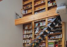 Slim-staircase-in-front-of-the-bookshelf-connects-the-various-levels-217x155