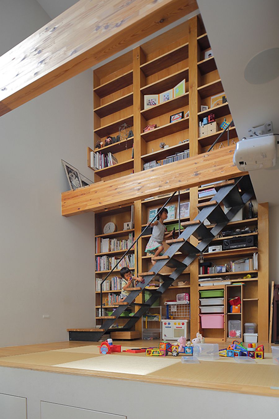 Slim staircase in front of the bookshelf connects the various levels