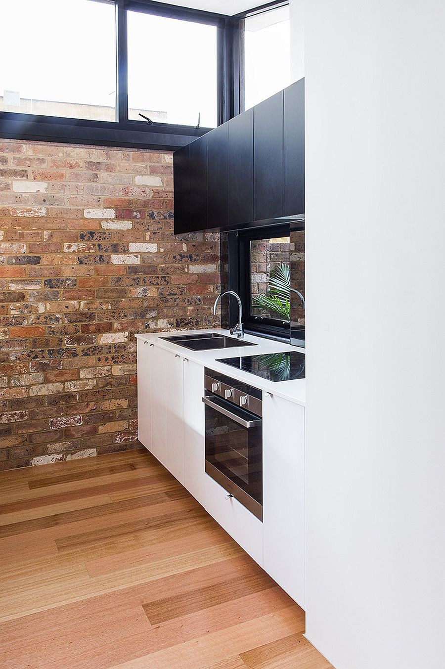 Small-corner-kitchen-idea-with-white-workstation-and-black-cabinets