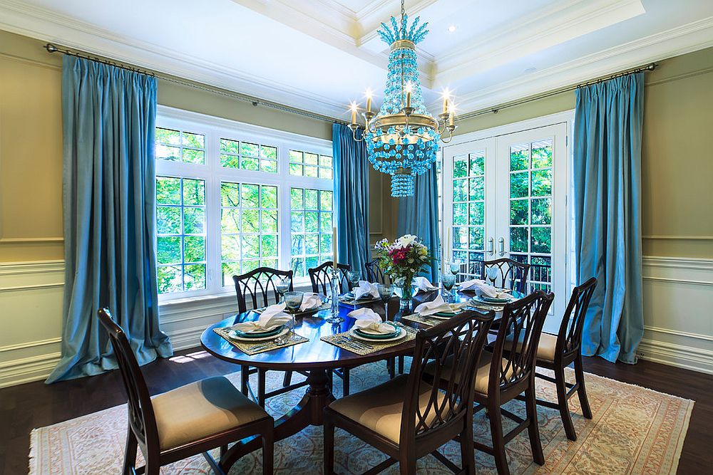 Superbe salle à manger avec un magnifique lustre bleu et des rideaux assortis