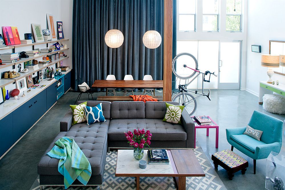 Tall blue drapes provide a curated backdrop for the spacious, chic living room