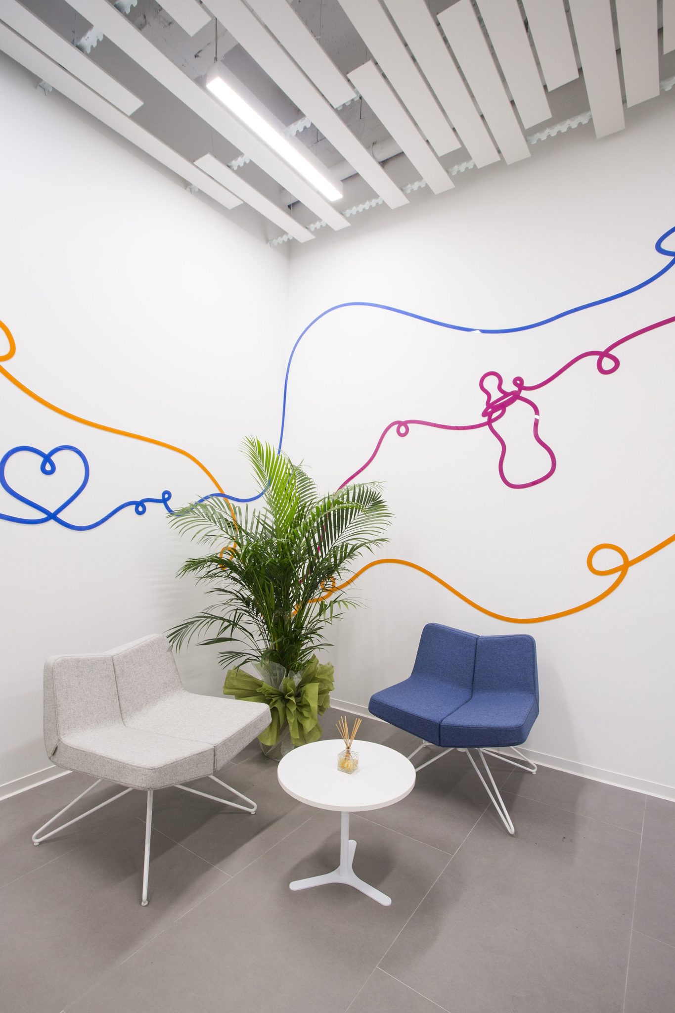 Waiting room in white of the office with a touch of color and whimsical pattern