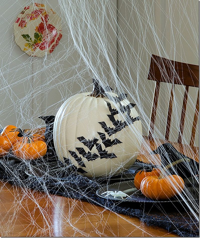 Decorating with bats across a white pumpkin is a great way to create a chic Halloween table