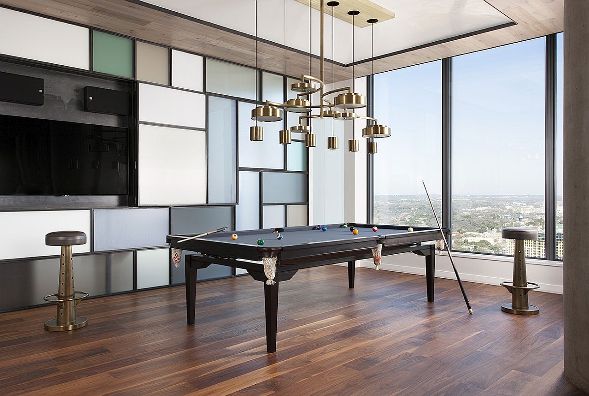 Dining table transformed into the pool table with chandelier above that also morphs