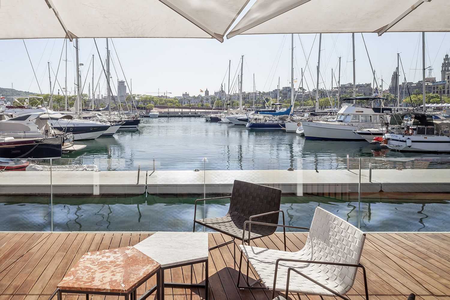 Geo style marble top tables and chic chairs create a wonderful sitting space next to the ocean