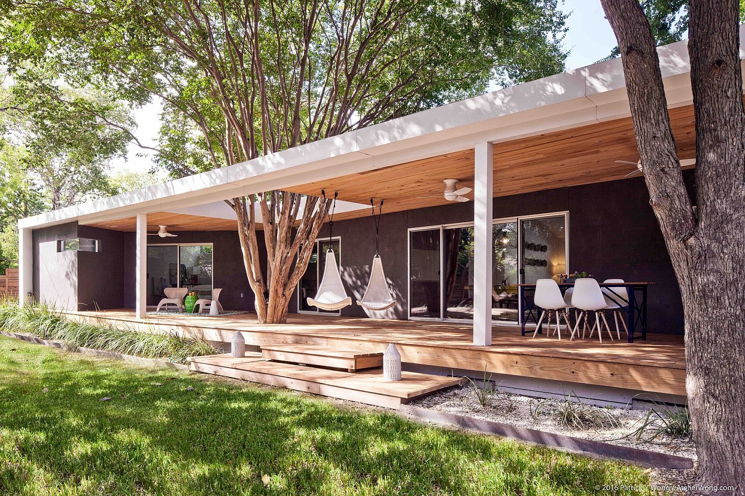 Large-porch-of-the-Texas-home-with-hanging-chairs-and-outdoor-dining
