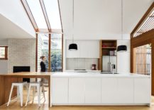 Modern-kitchen-in-white-with-wooden-cabinets-and-extended-breakfast-bench-217x155