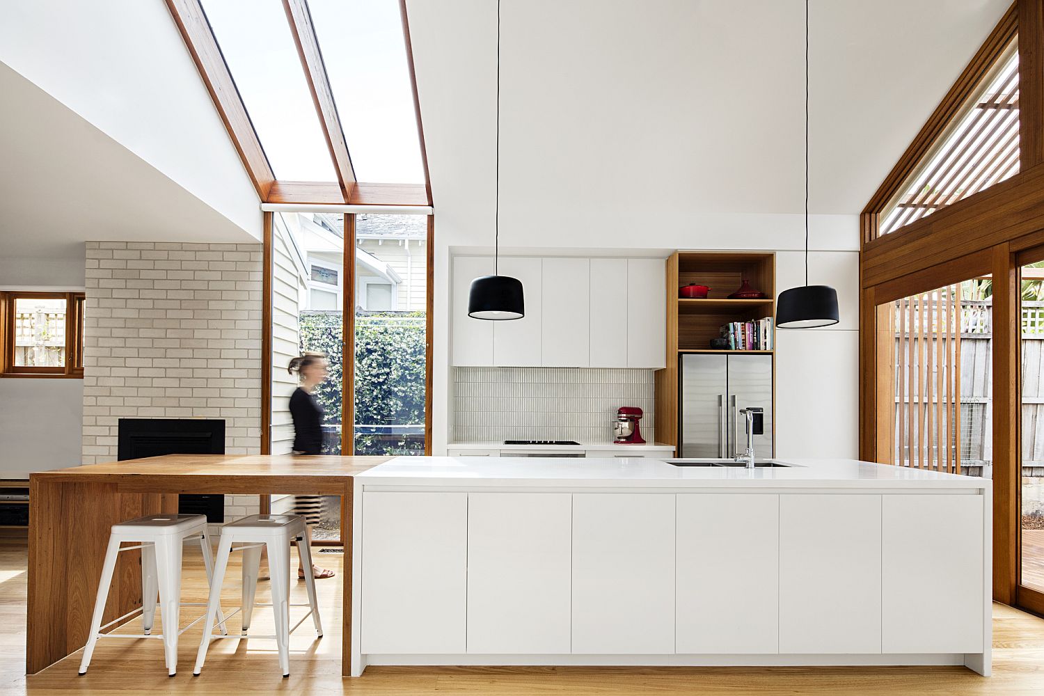 Modern kitchen in white with wooden cabinets and extended breakfast bench