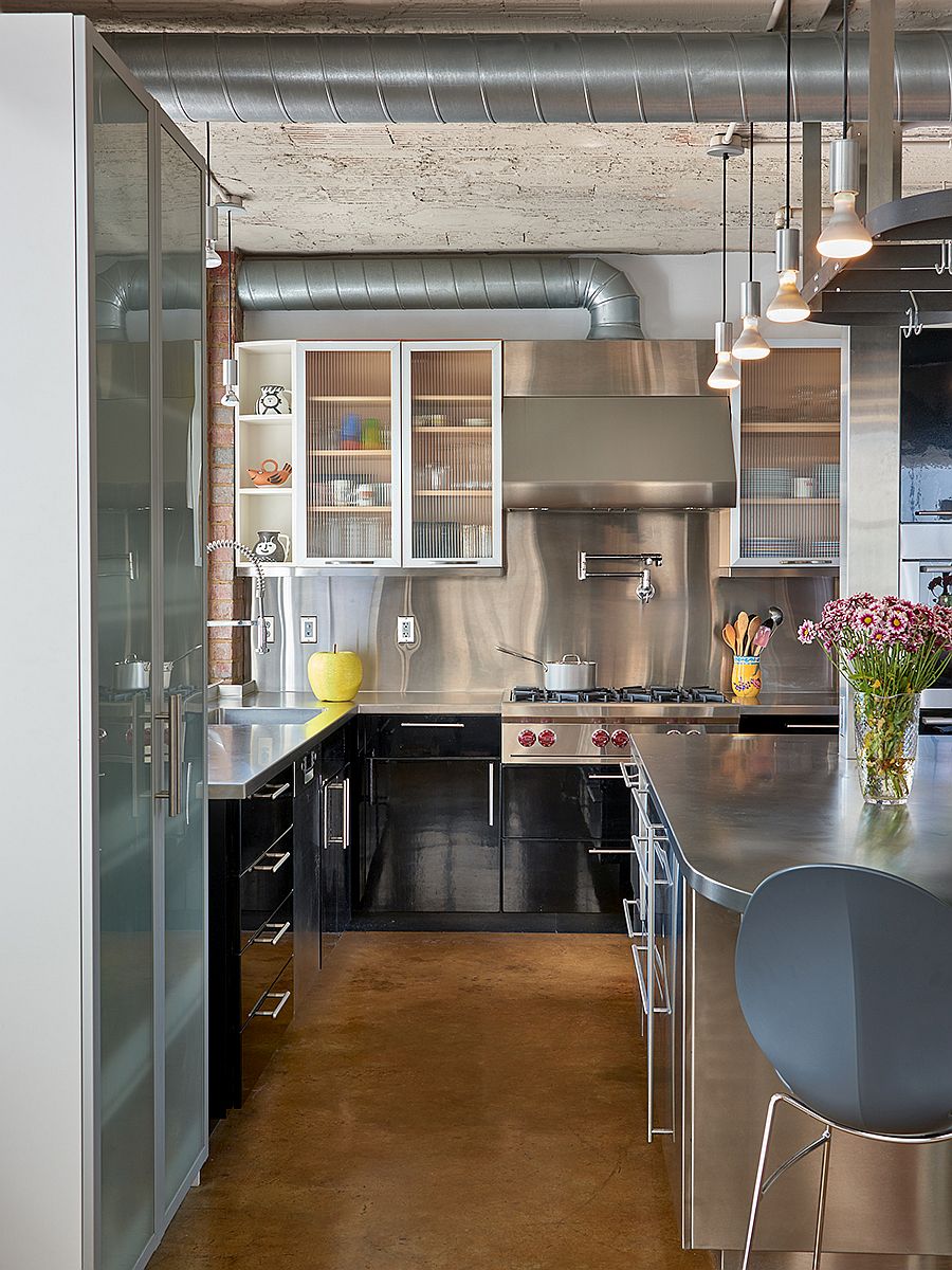 Open duct pipes and steel appliances give the kitchen an industrial edge