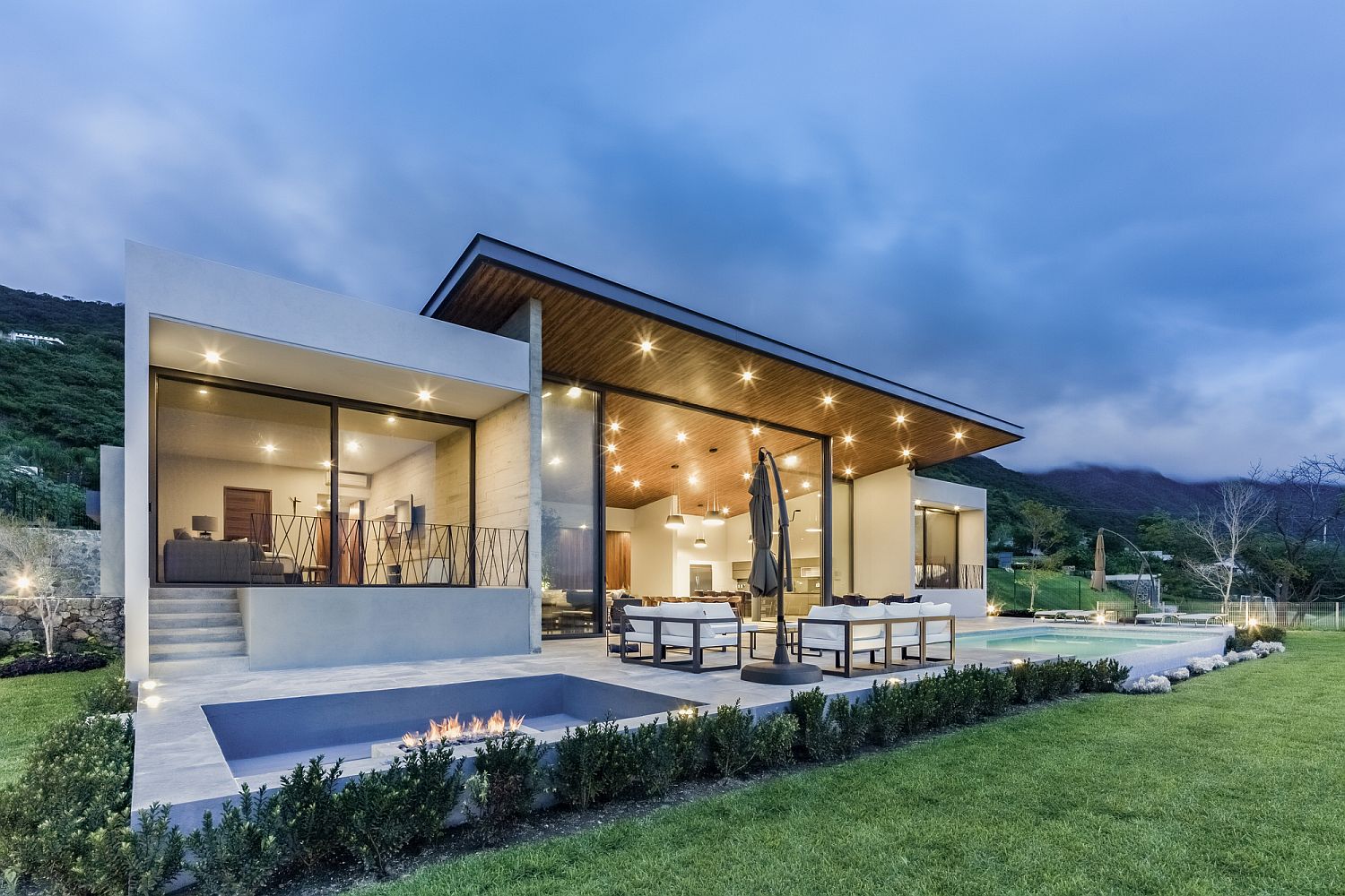 Outdoor sunken lounge with firepit next to the pool