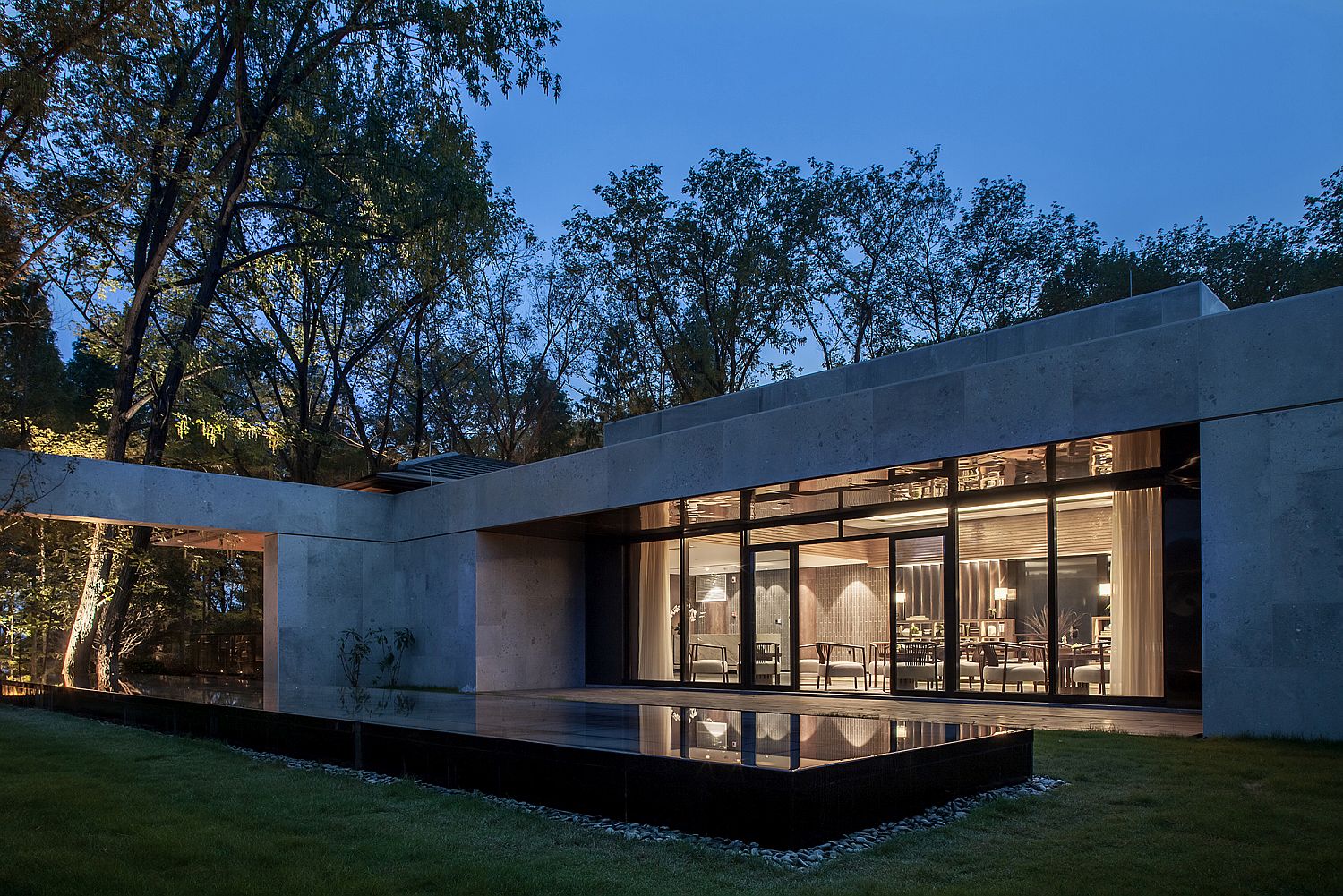 Platform with black mirror and rocks imitates the aesthetics of a reflecting pool