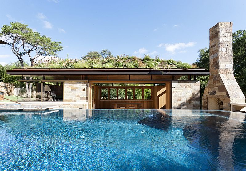 Poolhouse with dining and kitchen and a fireplace outside