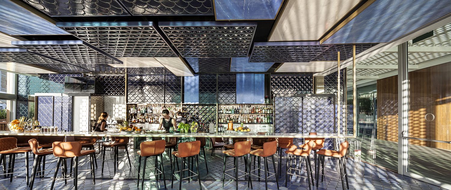 Stunning ceramic tiles ranging from navy blue to white shape a mesmerizing oceanside bar