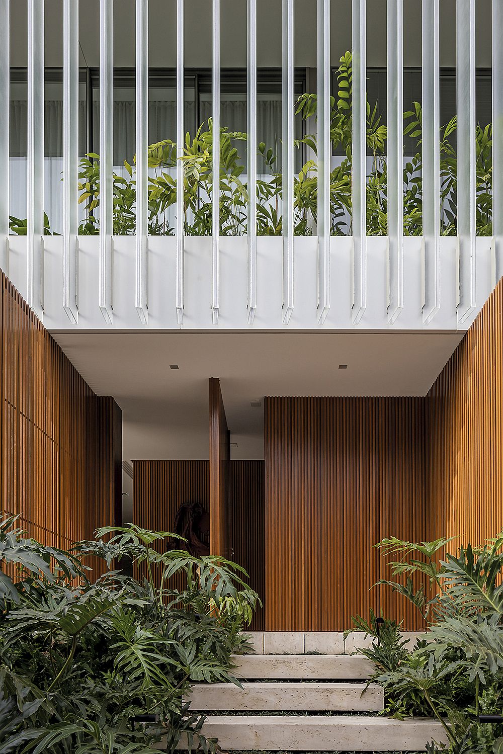 Swiveling front door of the contemporary home with a cool, green entryway around it