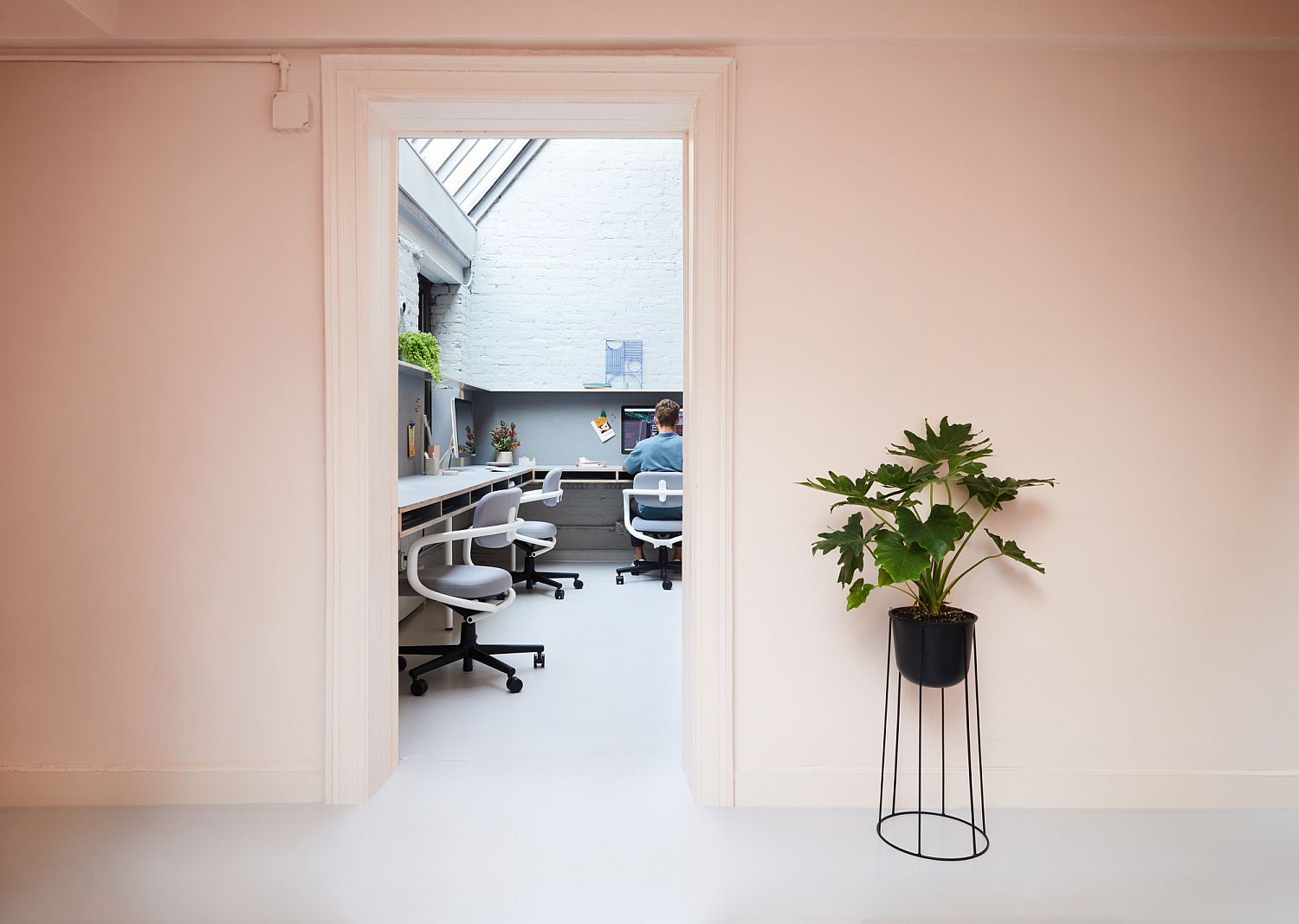 Walls draped in pastel pink create an inimitable office