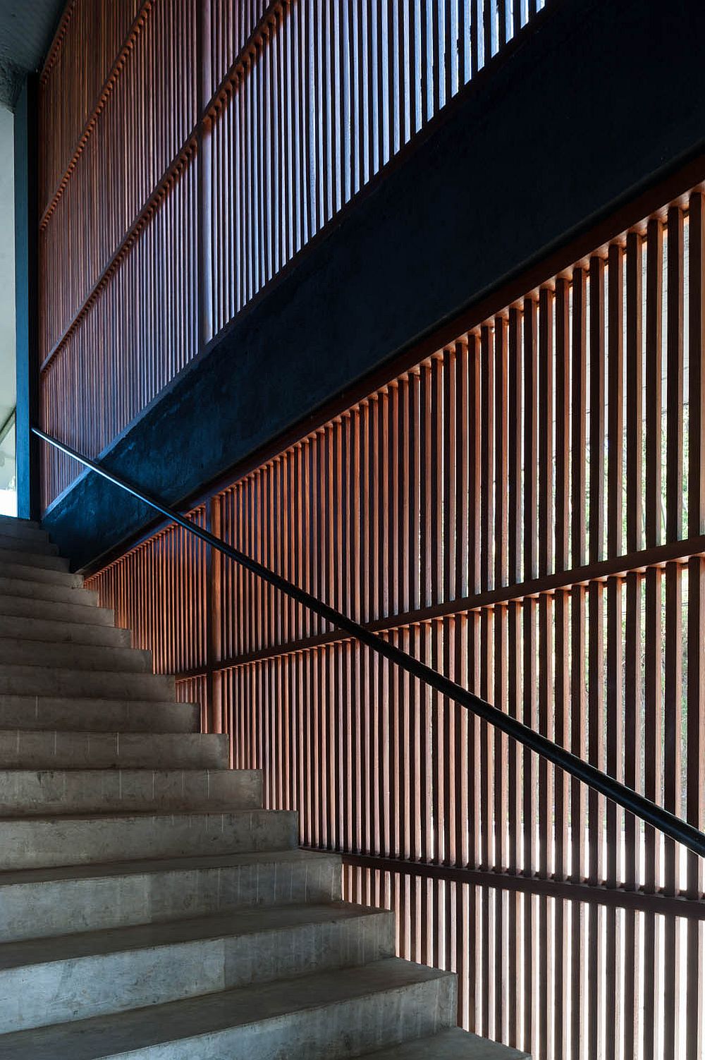 Wooden slats next to the stairs bring in ample natural light