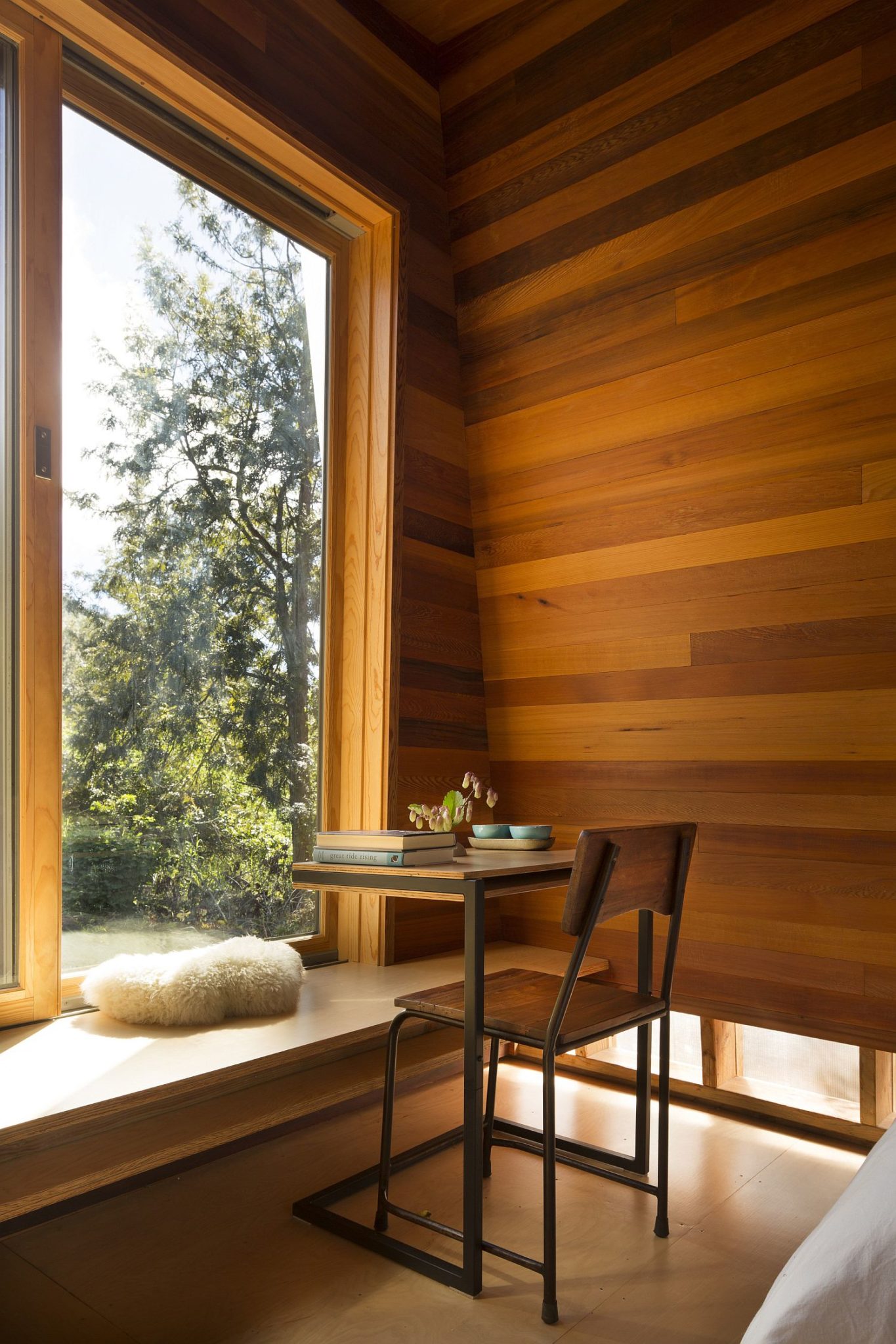 Bench next to the window along with a small chair and desk serves multiple purposes