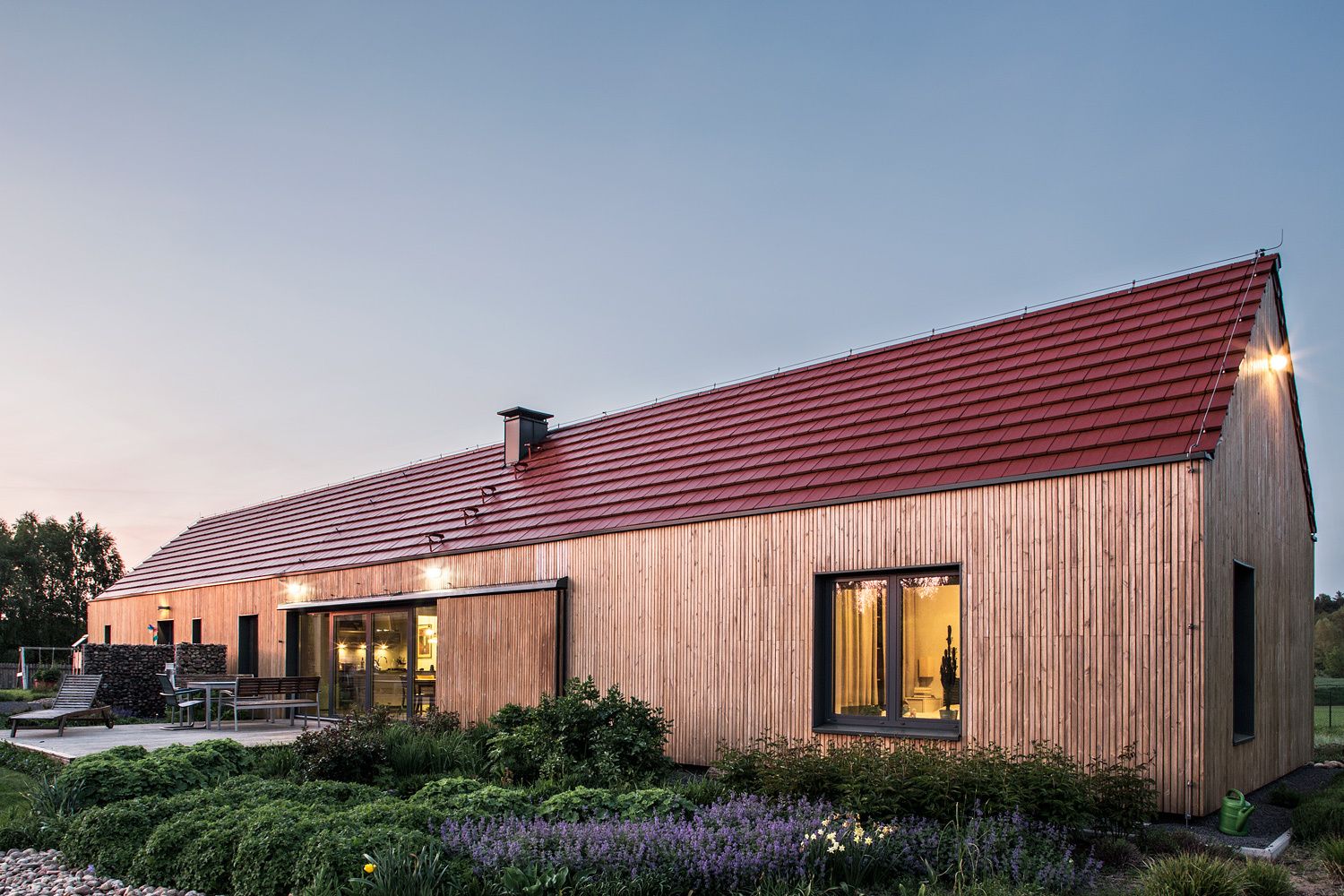 Ceramic red tile and vertically arranged pine boards give the modern home a traditional exterior