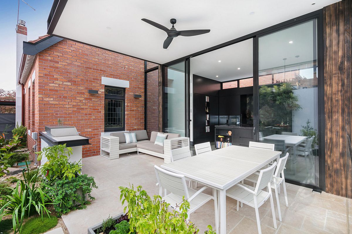 Covered alfresco dining and sitting area that flows into the backyard