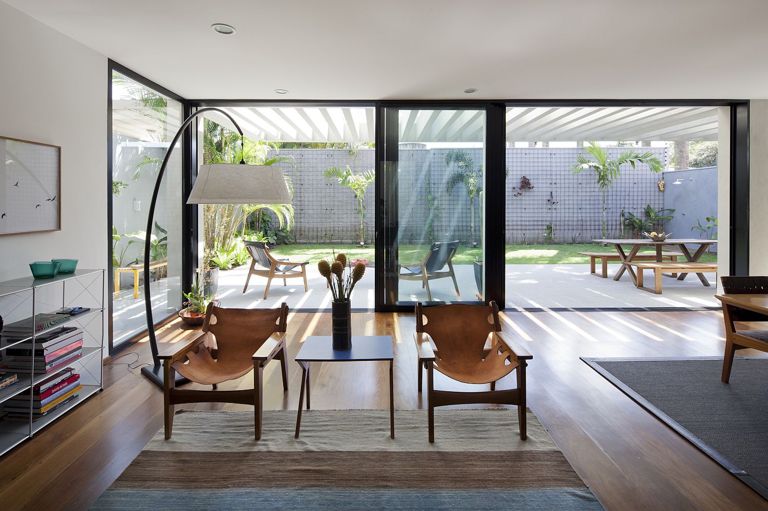 Dark framed glass doors connect the living area with the outdoor dining and backyard