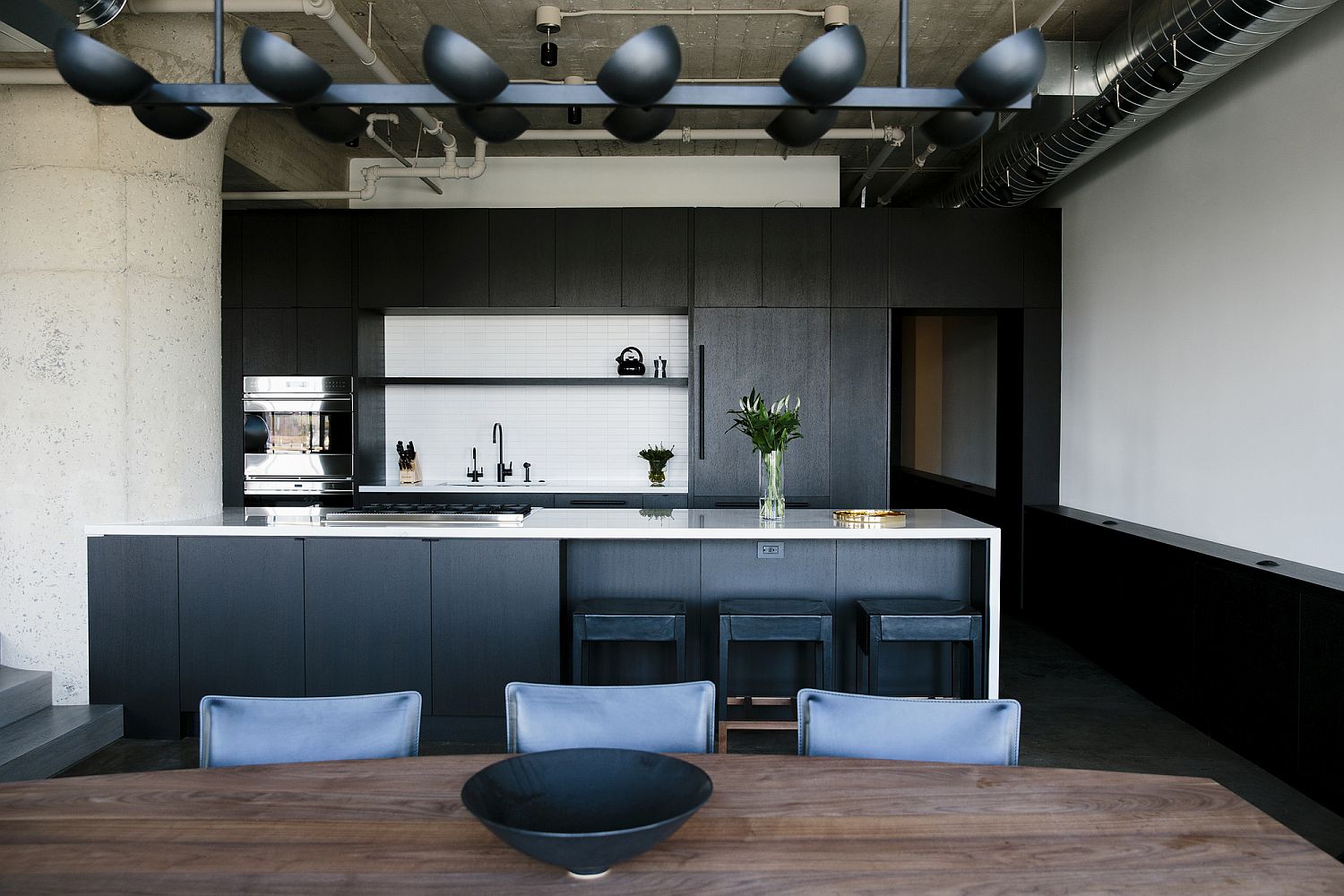 Fabulous kitchen in black with stunning lighting and an island in bluish-gray