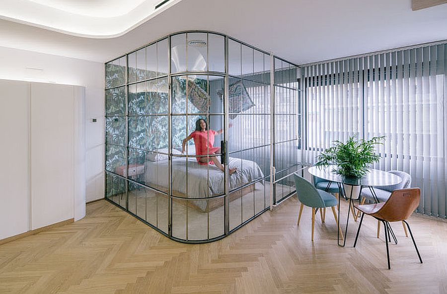 Glass walls delineate space in the small apartment without blocking light