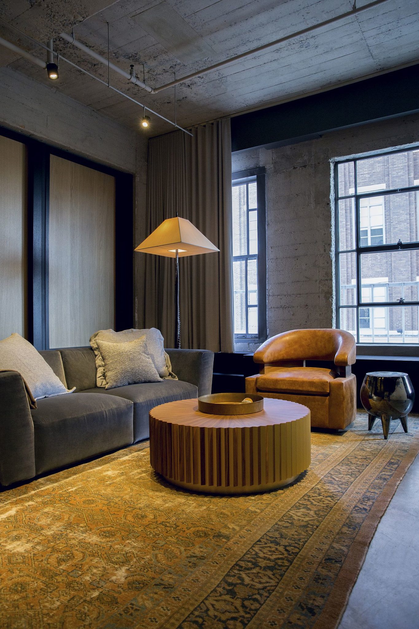 Gorgeous use of carpet and floor lamp brings a dash of yellow to the steely, industrial loft