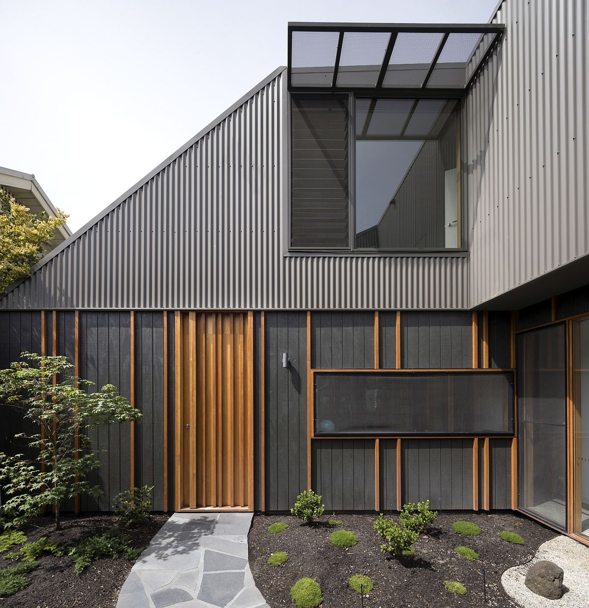 Gray exterior and curated courtyard of the low cost Aussie home