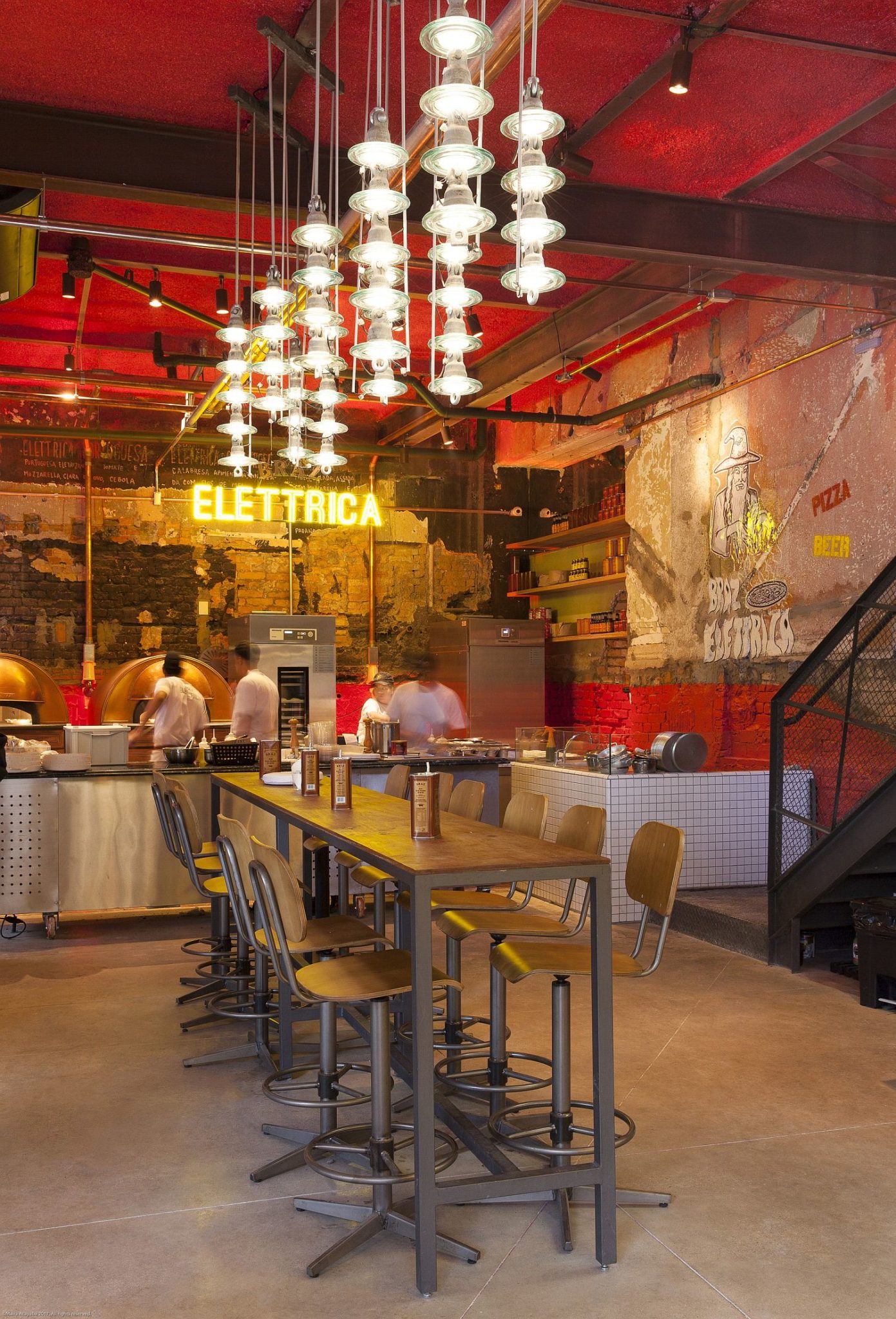 Illuminated signs on the all, dazzling lighting and textured walls create a fabulous pizza house