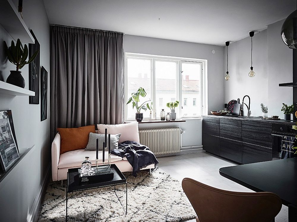 Light-filled living room of the apartment in white with large gray drapes