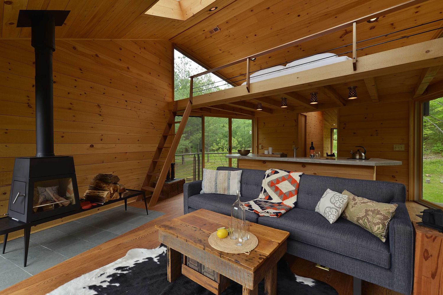 Lounge and loft level bedroom of the cabin in woods