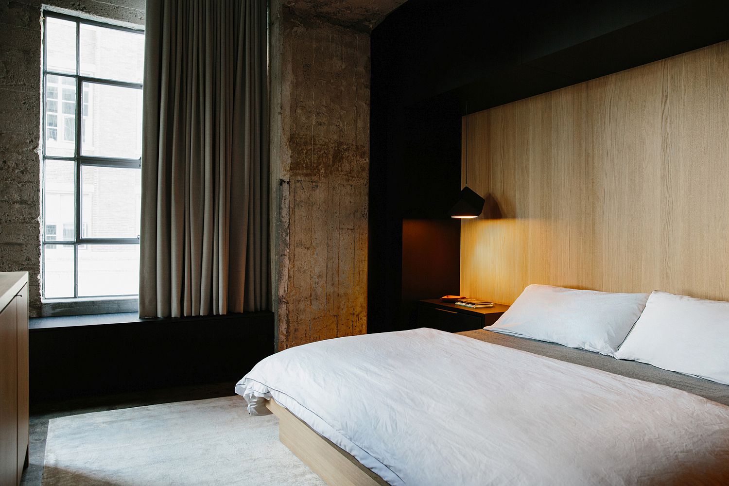 Minimal industrial bedroom with an accent wooden wall