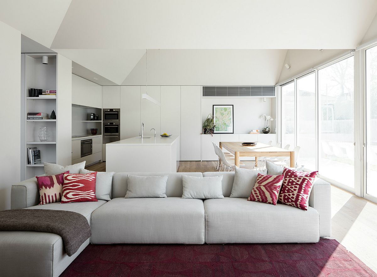 Rug and accent pillows bring a touch of purple to the neutral living room