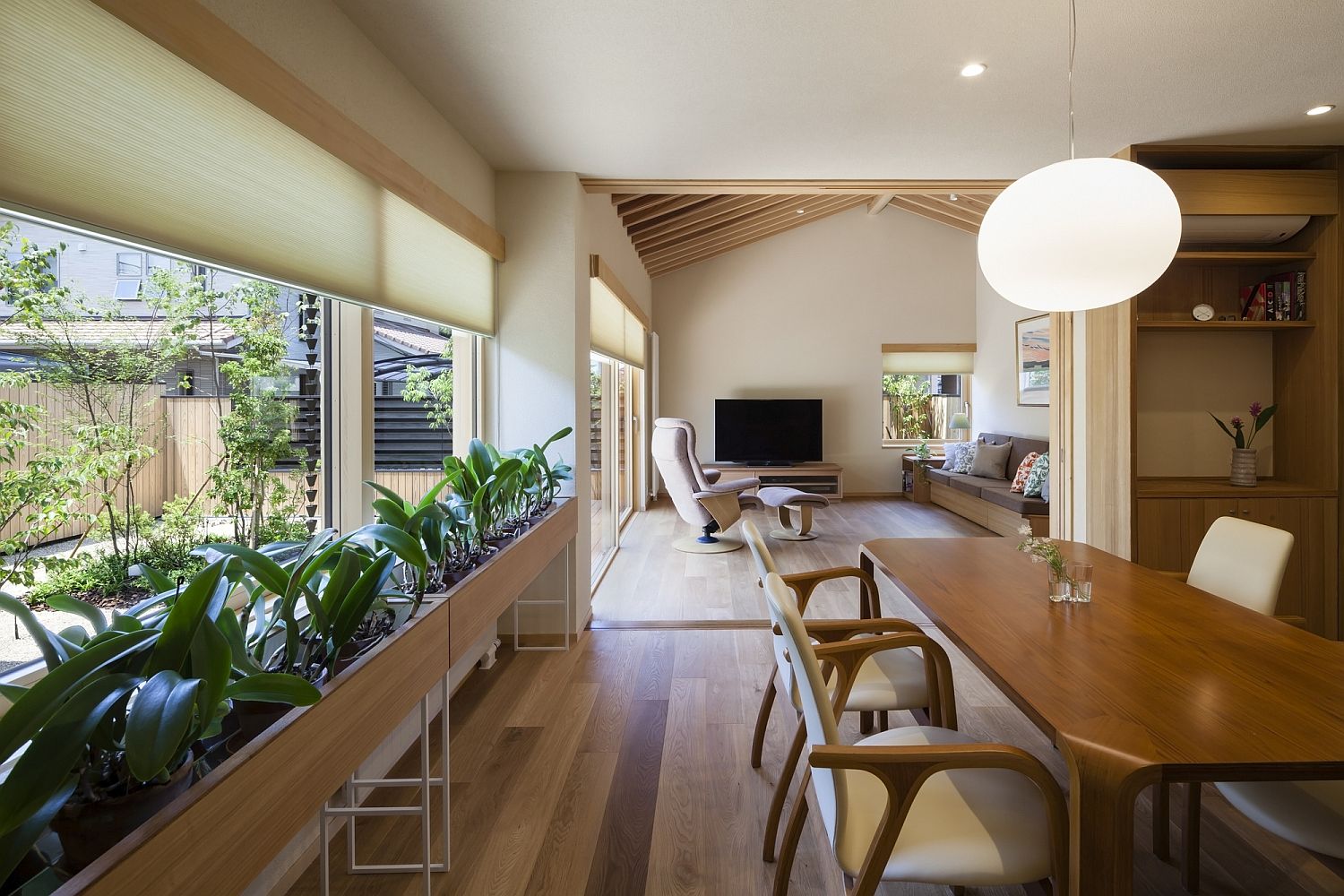 Series of plants in the dining room bring greenery to the modern Japanese home