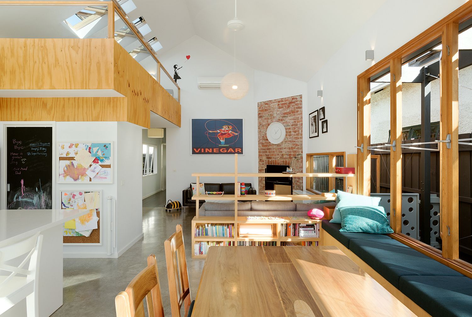 Simple wooden shelves used as room divider between the living area and dining