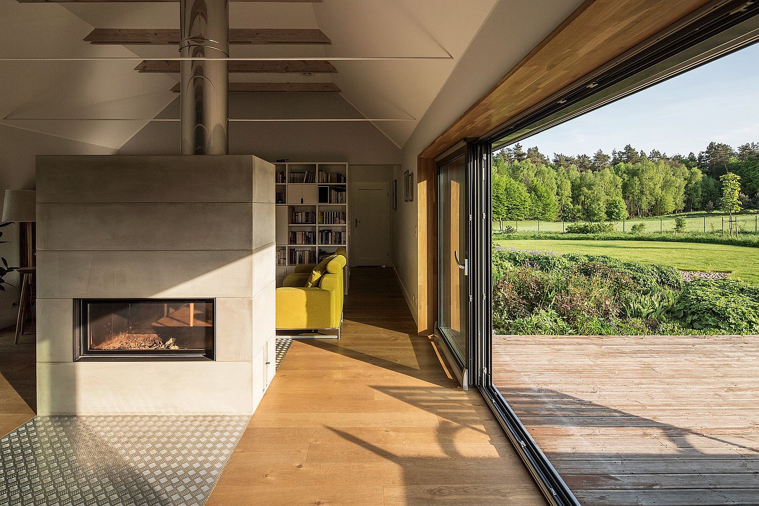 Sliding glass doors connect the living area and fireplace with the sunny deck outside